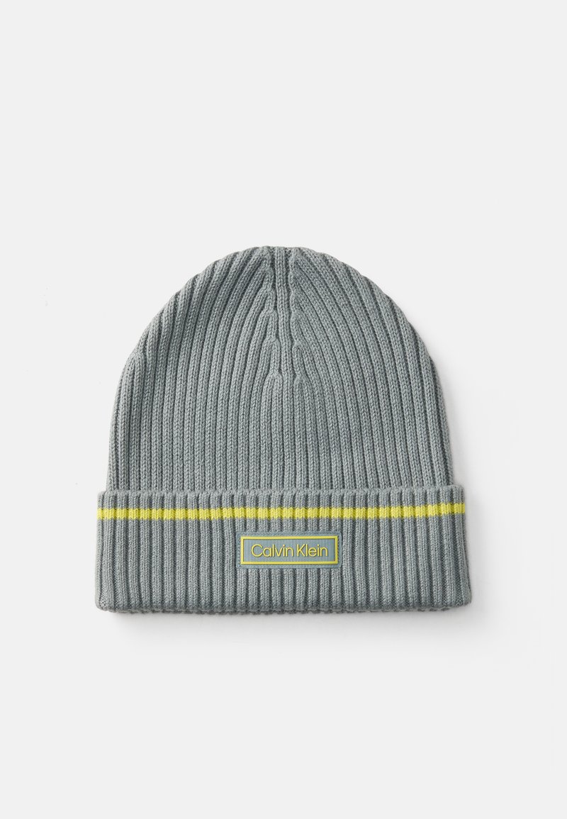 Szara dziergana czapka beanie o prążkowanej fakturze, z żółtym paskiem i prostokątną naszywką z logo Calvin Klein na złożonym mankiecie.