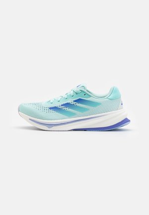 Scarpe da corsa azzurro chiaro con parte superiore in rete, lacci piatti e suola testurizzata. Presenta tre strisce blu sul lato e una suola intermedia imbottita.