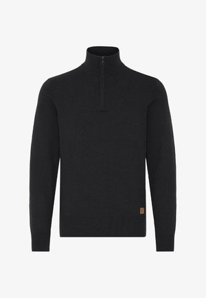 Pulover negru cu mâneci lungi, cu fermoar până la un sfert la gât și o etichetă mică de culoare maro aproape de tiv, pe partea dreaptă a faței.