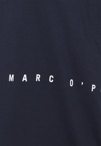 Mörkblå bomullströja med vittryckt text "MARC O'POLO" i en fet sans-serif-typsnitt över framsidan.