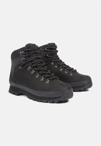 Stivali da trekking neri realizzati in pelle e materiale sintetico. Presentano occhielli in metallo, suola in gomma spessa e lacci texturizzati per una vestibilità sicura.