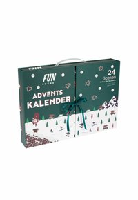 Pudełko kalendarza adwentowego w ciemnozielonym kolorze z białą zimową sceną, ozdobione wstążką, płatkami śniegu, drzewami i świątecznymi ilustracjami.