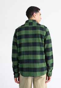 Grøn- og sortternet flannel skjorte med knapmansjetter, lige kant og spidse kraver. Blød tekstur med en afslappet pasform.