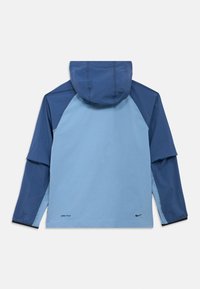 Ανοιχτό γαλάζιο και ναυτικό μπλε μπουφάν με κουκούλα, λογότυπο DRI-FIT στο τελείωμα και μανίκια ράγκλαν, κατασκευασμένο από αδιάβροχο υλικό.