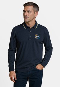 Marineblauw poloshirt met lange mouwen en een meerkleurige gestreepte kraag, voorzien van een grafische tekst en logo op de linkerborst. Casual pasvorm, gestructureerde stof.