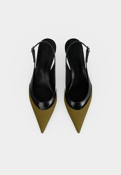 Para damskich butów typu slingback z wąskim czubkiem, z oliwkowozieloną przednią częścią, czarną skórzaną wyściółką i paskiem na białym tle.