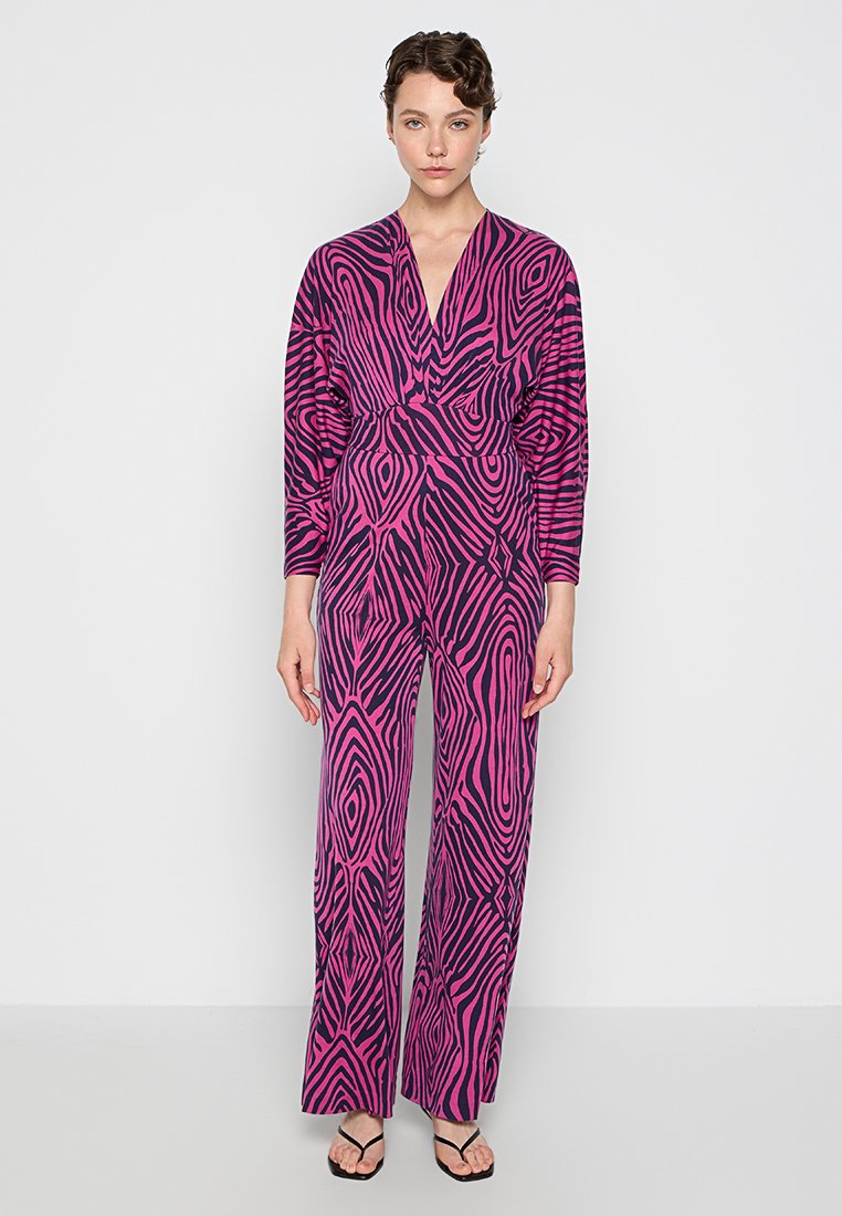 Jumpsuit z długim rękawem z odważnym różowo-czarnym, abstrakcyjnym wzorem zebry, z dekoltem w serek i luźnym krojem oraz rozszerzanymi nogawkami.