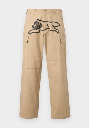 Pantaloni cargo beige con due tasche laterali, una vestibilità comoda e una grafica nera prominente di una figura che salta sulla parte anteriore.