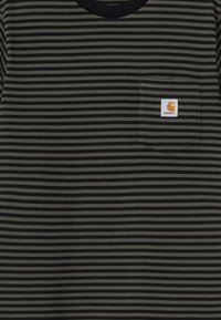 Camiseta a rayas negra y verde olivo con cuello redondo y bolsillo en el pecho. Presenta el logo de Carhartt en el bolsillo. Material de algodón.