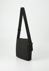 Borsa a spalla nera con design piatto, realizzata in tessuto resistente, dotata di tracolla regolabile e tasca frontale per riporre gli oggetti.