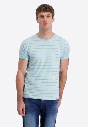 Man wearing light blue, short-sleeve striped T-shirt and blue jeans, standing against a plain white background.