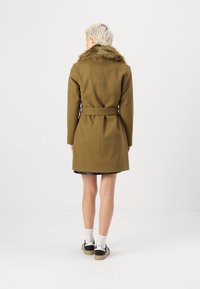 Brun uldfrakke med en faux fur-krave, bæltestropp, og lange ærmer; skåret til midt på låret, med en skræddersyet pasform og glat tekstur.