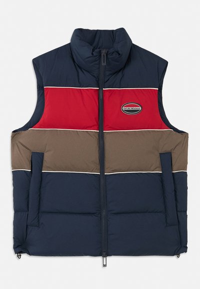 Gevoerde mouwloze vest met een hoge kraag. Kleurverloop ontwerp in marineblauw, rood en bruin, met logo patch en ritssluiting aan de voorkant.