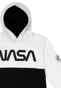 Felpa con cappuccio bianca e nera, con grande scritta "NASA". Il materiale sembra morbido; include una toppa con un design circolare sulla manica.