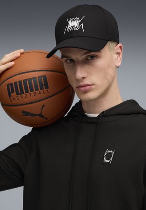 Black cap with white logo, black hoodie, and a basketball featuring an embossed logo. Smooth textures, simple design, sporty aesthetic.