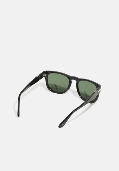 Black sunglasses with green tinted lenses, rectangular frame, and glossy finish. Includes metal accents on the arms for added detail.