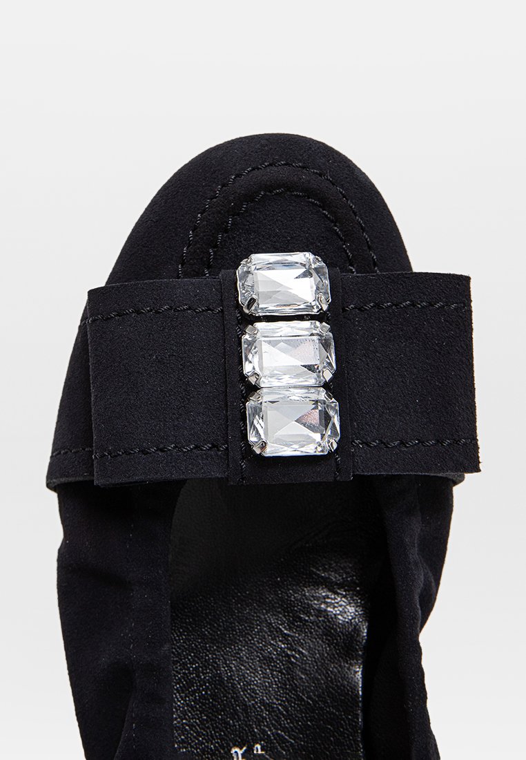 Schwarzer Wildlederschuh mit breitem Riemen, der mit drei rechteckigen, klaren Strasssteinen verziert ist, mit abgerundetem Zehenbereich und glattem schwarzem Innenfutter.