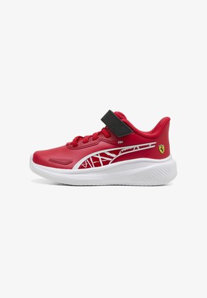 Červená športová obuv s bielou podrážkou, čiernym suchým zipsom, bielym logom Puma a malým žltým emblémom Ferrari na päte.