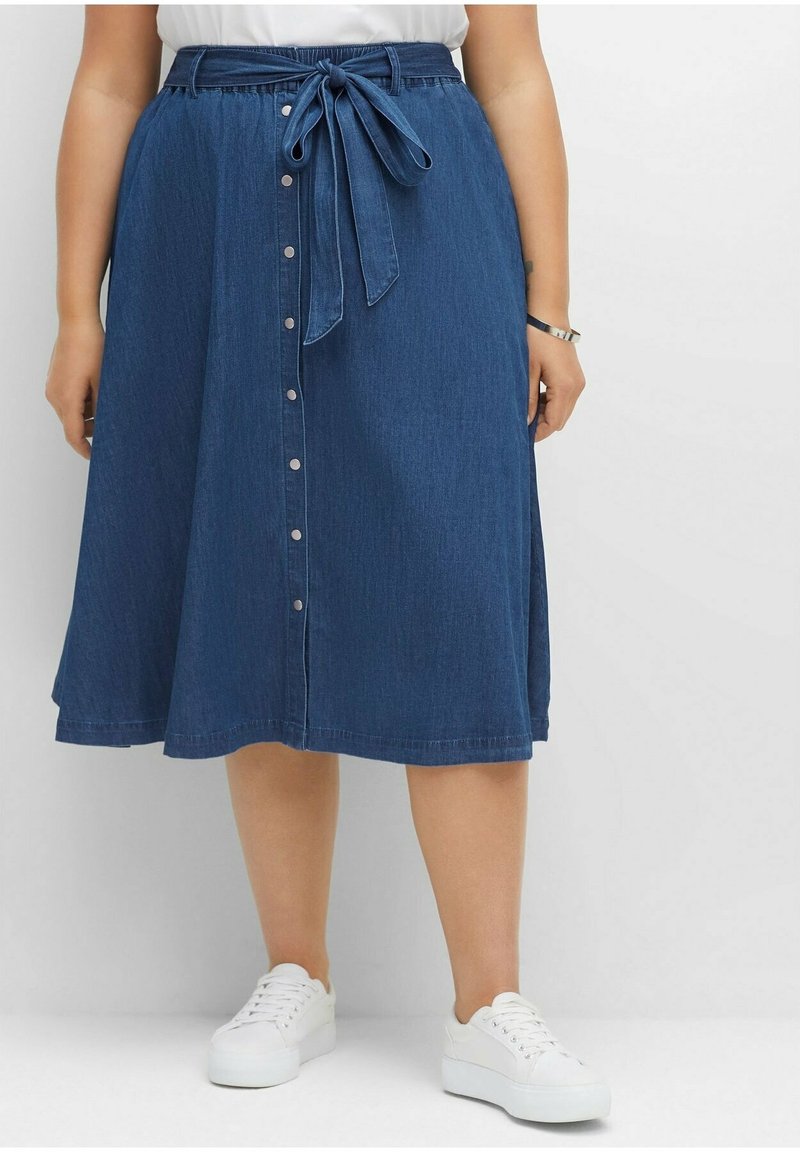 Džínsová midi sukně s páskem v pase, zapínáním na knoflíky vpředu a rozšířeným střihem. Barva je tmavě modrá, s hladkou texturou a jemným prošíváním.