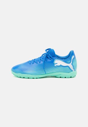 Scarpe da calcio sintetiche blu con una parte superiore testurizzata, design a gradiente e suola verde menta. Presentano un logo bianco prominente e lacci.