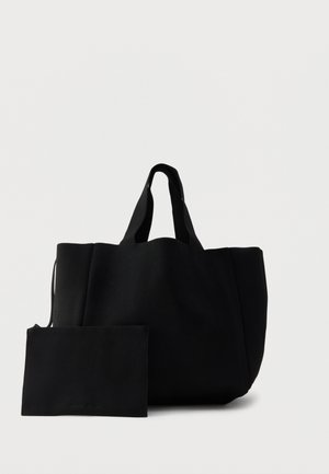 Sac cabas noir texturé avec deux petites poignées, accompagné d'une pochette rectangulaire assortie avec fermeture éclair, sur fond blanc.