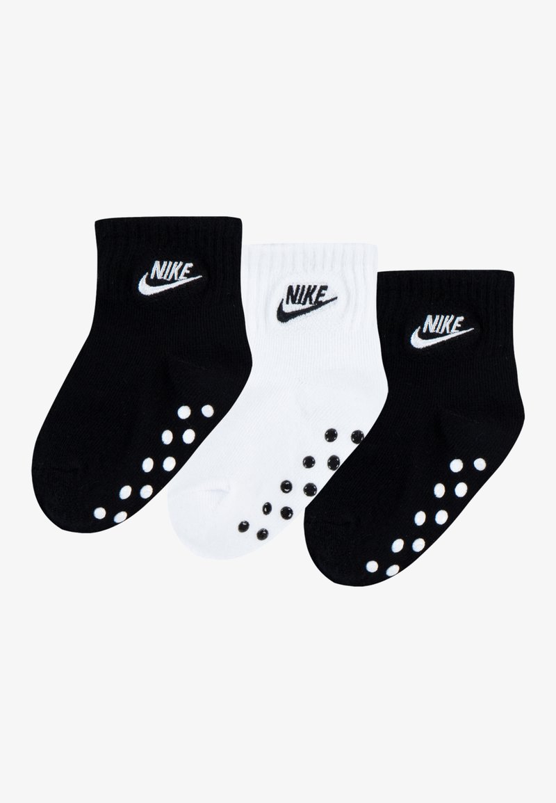 Pack of three cotton socks in black and white. Features ribbed cuffs, Nike logo, and rubber dots on the soles for grip.