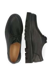 Chaussures en cuir noir à bout arrondi, dotées d'un design à lacets, d'une semelle en caoutchouc épaisse et de coutures visibles le long des bords.