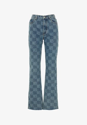 Pantalon en denim avec un délavage bleu clair, présentant un motif du logo 'WB' répété. Design évasé, style classique à cinq poches et fermeture à bouton.