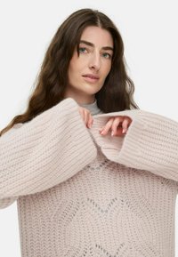 Helles rosa gestricktes Sweatshirt mit weit geschnittenen Ärmeln und einem strukturierten Muster. Hat einen lässigen Schnitt und einen runden Ausschnitt. Weiches, gemütliches Material.
