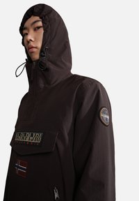 Dark brown waterproof jacket with a hood, featuring a front zip, a patch logo, and a Norway flag detail on the pocket.