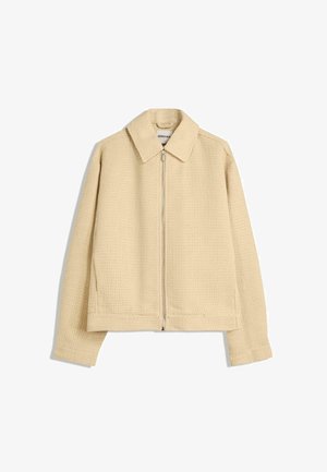 Beige, gestructureerde zip-up jack met een kraag, lange mouwen en twee zijzakken. Wafelbreipatroon door de stof.