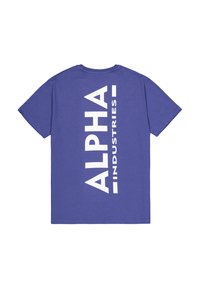 Lila pamut póló, amelyen a hátulján nagy fehér nyomtatásban szerepel az "ALPHA" és az "INDUSTRIES" függőlegesen elrendezve. Rövid ujjú, kerek nyakú dizájn.