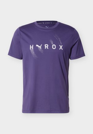 Lilla lühikeste varrukatega spordisärk, millel on ees keskosas tekst "HYROX" ja Puma logo, mis asendab tähe "Y".
