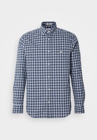 Granatowo-biała kratowana koszula z długim rękawem, kołnierzykiem na guziki i guzikami z przodu. Tekstura tkaniny wydaje się gładka i lekka.