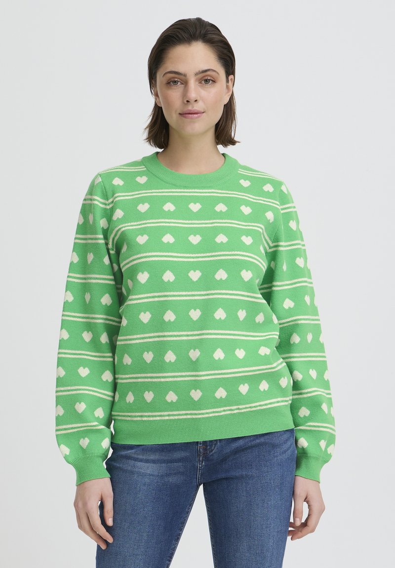 Pull vert en tricot avec motifs de cœurs blancs et rayures horizontales. Poignets et encolure côtelés. Matière en mélange de coton, coupe décontractée.