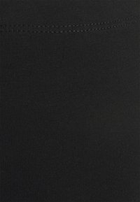 Leggings neri realizzati in un tessuto elastico e morbido, con una leggera costina e un bordo pulito in vita, progettati per il comfort e la versatilità.