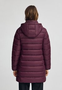 Maroon vadderad jacka med huva, med horisontella kviltade sektioner och en strömlinjeformad design. Tyget ser slätt och glänsande ut.