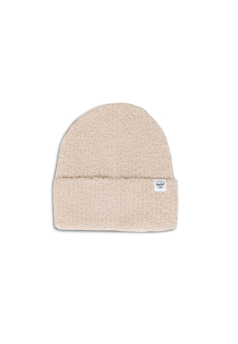 Berretto beige chiaro realizzato in materiale morbido e peloso. Presenta un risvolto e una piccola etichetta con logo di lato.