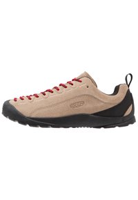 Beige suede low-top shoes with red laces, black rubber sole, and mesh accents near the heel for breathability and comfort.