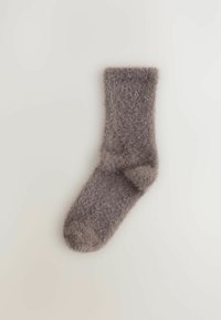 Harmaa pörröinen sukka, jossa on pehmeä texture, kaitalevarren ja pyöristetty varvas. Valmistettu lämpimästä, kevyestä materiaalista.