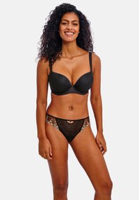 Black lace bra with molded cups and adjustable straps, paired with a black sheer thong featuring floral embroidery and a cutout detail.