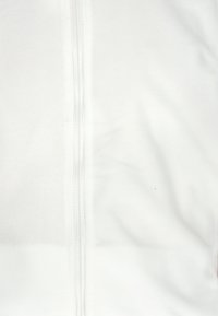 Die weiße Fleecepulloverjacke verfügt über einen Frontreißverschluss, eine glatte Textur und einen subtilen Glanz. Der Stoff wirkt weich, ohne sichtbare Muster oder Akzente.