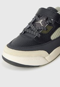 Μαύρο δερμάτινο αθλητικό παπούτσι με υφή στη μύτη, σουέτ λεπτομέρειες, ελαστικά κορδόνια και πάνελ από δίχτυ σε ανοιχτό γκρι, με εμφανές λογότυπο στη γλώσσα.