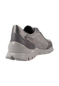 Zapatilla de cuero gris con una textura suave, forma redondeada y suela de goma. Presenta costuras sutiles y la marca Geox en el talón.