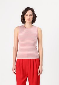 Top senza maniche di colore rosa chiaro con righe orizzontali bianche, realizzato in un tessuto liscio. Abbinato a pantaloni rossi a vita alta, modello di fronte.