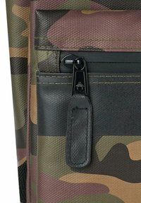 Borsa con motivo camouflage e superficie testurizzata, dotata di ferramenta per cerniere nera e un tirante in pelle. I colori includono verde, marrone e beige.