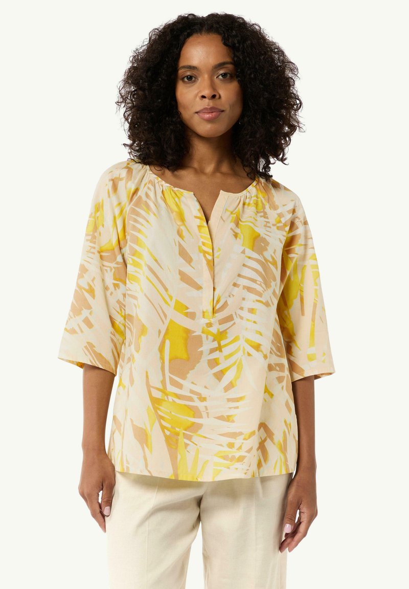 Leichte, cremefarbene Bluse mit gelbem und beigem abstraktem Blättermuster, 3/4-Ärmel und einer lockeren Passform. Subtiles Ausschnittdesign fügt Detail hinzu.