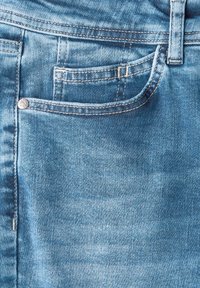 Vaaleansiniset denimit, joissa on sileä rakenne, etutasku, erottuva ommel ja metallinappi.