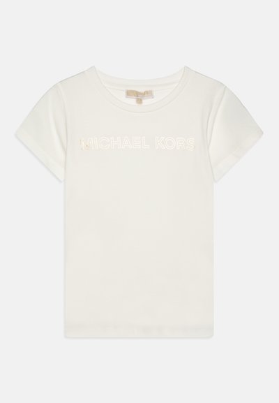 Camiseta de algodão branca com mangas curtas, apresentando "MICHAEL KORS" impresso em dourado metálico. Decote redondo, textura suave.