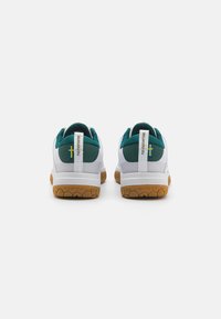Hvide sneakers med teal detaljer og en struktureret gummisål. Har en bagtab og et lille flagdetalje på hælen.